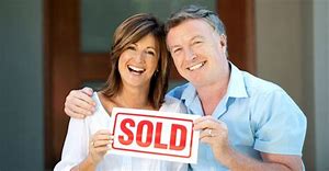 couple showing sold signboard